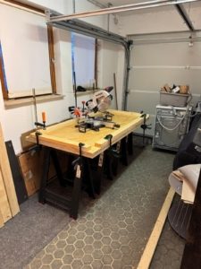 Provisorischer Arbeitstisch mit Kappzugsäge in der Garage während des Werkbankbaus