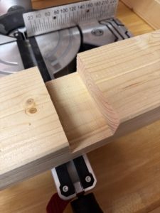 Detailaufnahme eines KVH-Holzbalkens mit sauber gesägter Aussparung beim Werkbankbau in der Garage